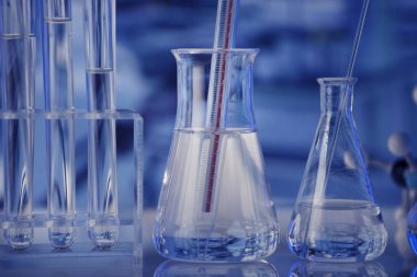 Laboratuvar konsepti. Mavi arka planda cam tüpler ve beherler.