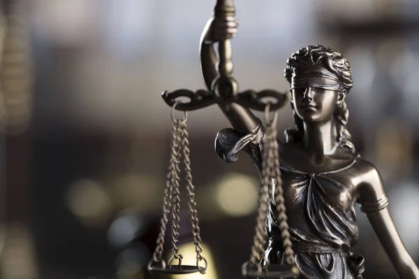 Law symbols in the old university library.  Books, gavel, scale, statue of justice.