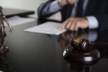 Bir avukat kavramı ile istişare. Avukat ofiste. Çekiç ve cam masa üzerindeki belgeler.