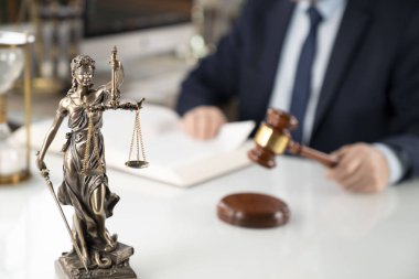 Avukat kavramı arka plan. Ofiste çalışan avukat. Tokmak, Themis heykeli ve beyaz cam masa üzerinde yasal kitap.