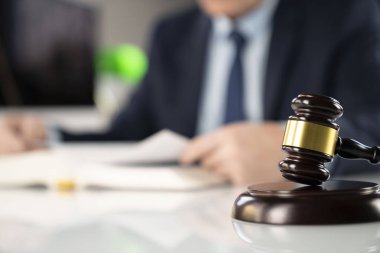 Avukat kavramı arka plan. Ofiste çalışan avukat. Tokmak ve beyaz cam masa üzerinde yasal kitap.