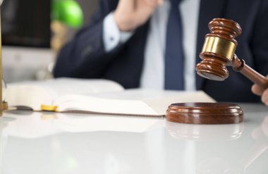 Avukat kavramı arka plan. Ofiste çalışan avukat. Tokmak ve beyaz cam masa üzerinde yasal kitap.