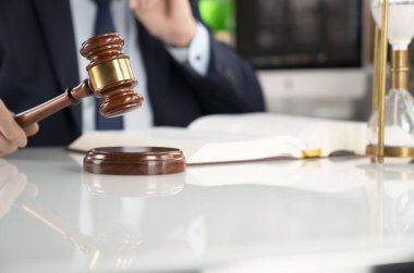 Avukat kavramı arka plan. Ofiste çalışan avukat. Tokmak ve beyaz cam masa üzerinde yasal kitap.