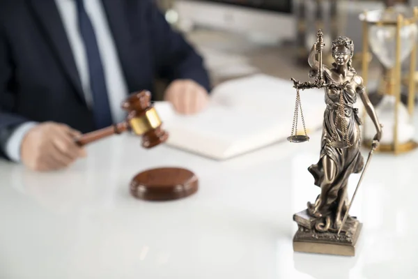 Lawyer concept background. Lawyer working at the office. Gavel, Themis statue and legal book on the white glass table.