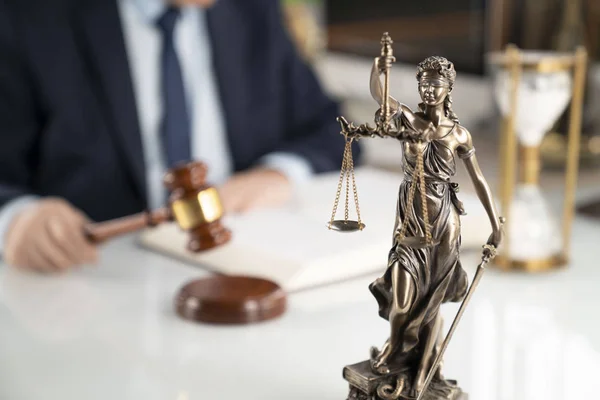 Lawyer concept background. Lawyer working at the office. Gavel, Themis statue and legal book on the white glass table.