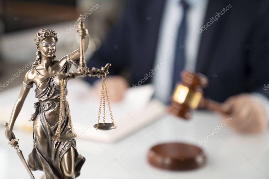 Lawyer concept background. Lawyer working at the office. Gavel, Themis statue and legal book on the white glass table.