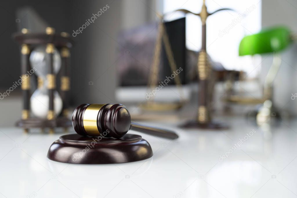 Law concept background. Gavel on the white glass table in the lawyer office.