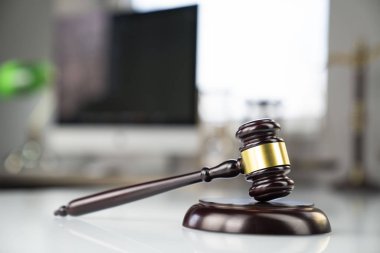 Avukatlar ofisi. Tokmak ve beyaz masa üstünde bilgisayar.