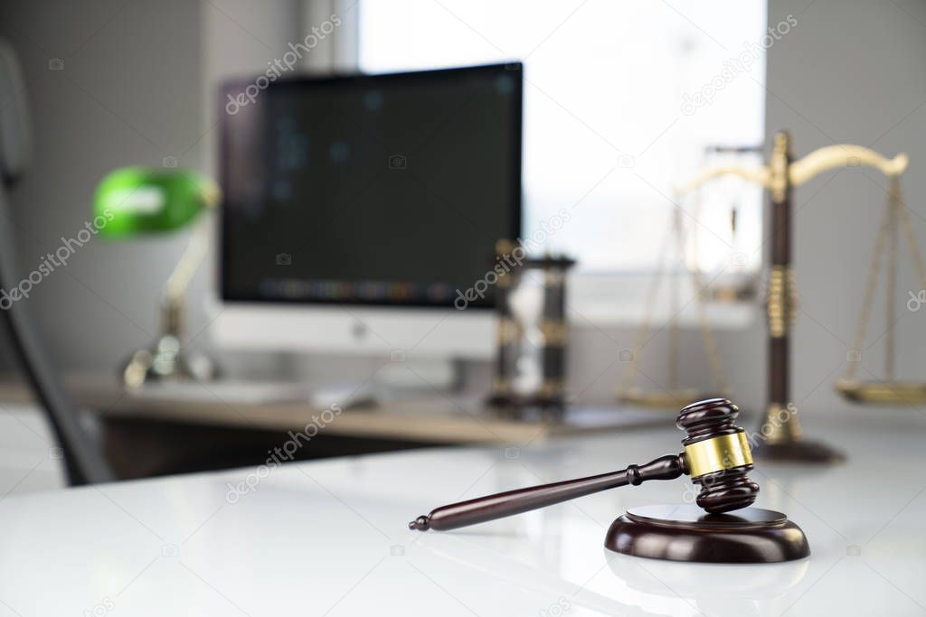 Lawyers office. Gavel and computer on the white table.