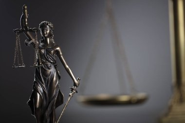 Hukuk kavramı arka plan. Themis heykeli ve gri arka planda ölçek.