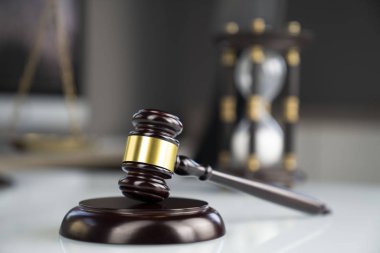 Avukatlar ofisi. Tokmak ve beyaz masa üstünde bilgisayar.