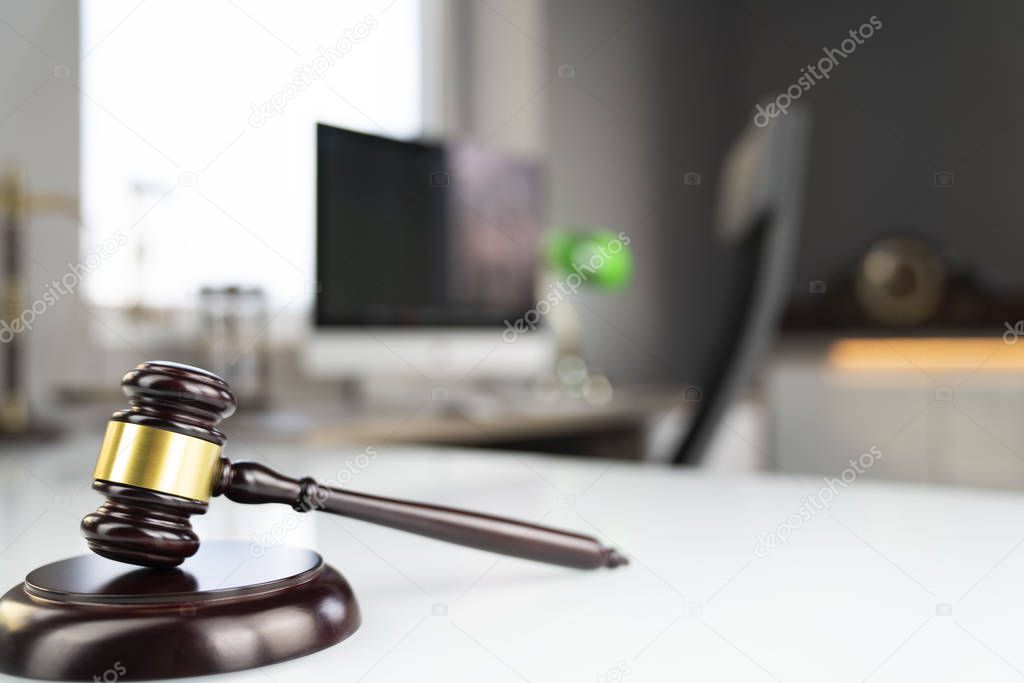 Lawyers office. Gavel and computer on the white table.