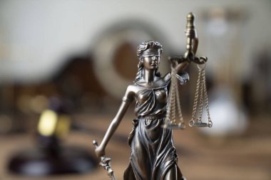 Hukuk sembolleri Themis ve rustik ahşap masa üzerinde hakimin tokmak.