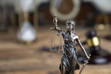 Hukuk sembolleri Themis ve rustik ahşap masa üzerinde hakimin tokmak.