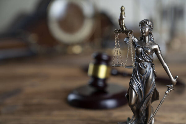 Символы закона Фемида и молоток судьи на деревенском деревянном столе
.