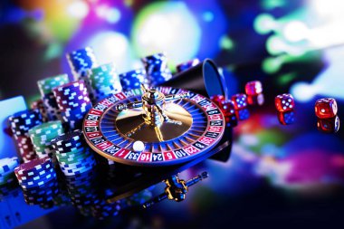 Gambling theme.  Roulette wheel and poker chips on color bokeh background. clipart