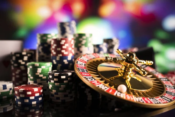 赌博主题 在彩色散景背景的轮盘赌轮和扑克筹码 — 图库照片