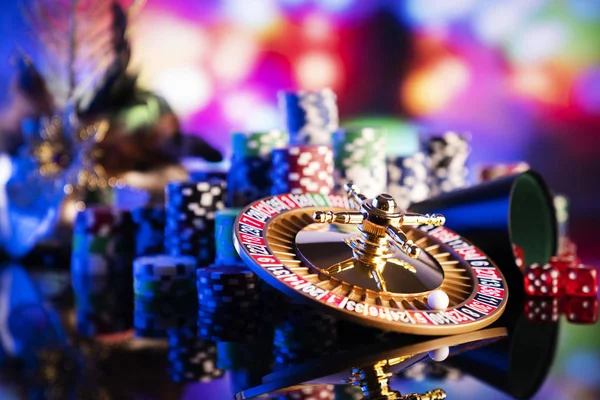赌博主题 在彩色散景背景的轮盘赌轮和扑克筹码 — 图库照片