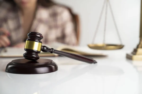 Female attorney in the legal office. Gavel and legal code on the white table.