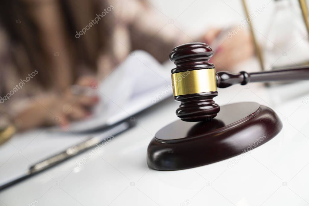 Female attorney in the legal office. Gavel and legal code on the white table.