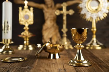 Katolik kavram arka plan. Haç, monstrance, İsa figürü, Kutsal Kitap ve sunak üzerinde altın kadeh.
