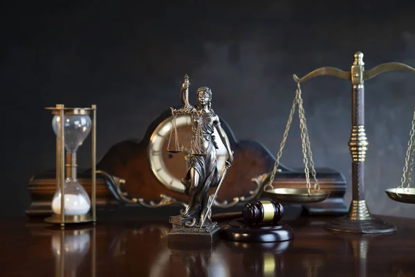 The law concept background.  Gavel of  the judge, Themis statue, the clock and the scale on the gray background.