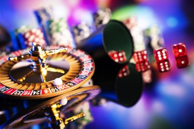 Casino teması. Renkli bokeh arka planda Rulet, zar ve poker fişleri.
