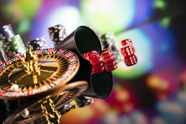 Casino teması. Renkli bokeh arka planda Rulet, zar ve poker fişleri.