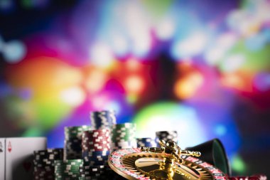 Casino teması. Renkli bokeh arka planda Rulet, zar ve poker fişleri.