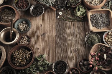 Baharat tema. Ahşap rustik masa üzerinde kase içinde baharatlar topluluğu. Metin veya tipografi için yer.