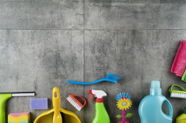 Sonbahar evi temizlik teması. Gri fayanslarda renkli temizlik ürünleri. Üst görüntü. Tipografi için yer.