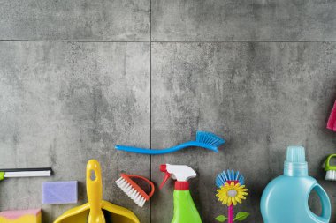 Sonbahar evi temizlik teması. Gri fayanslarda renkli temizlik ürünleri. Üst görüntü. Tipografi için yer.