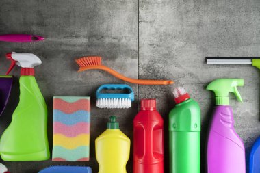 Sonbahar evi temizlik teması. Gri fayanslarda renkli temizlik ürünleri. Üst görüntü. Tipografi için yer.