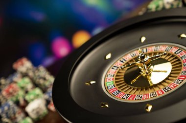 Kumarhane teması. Kumar oyunları. Renkli bir arka planda rulet ve poker fişleri.