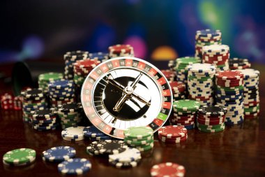 Kumarhane teması. Kumar oyunları. Renkli bir arka planda rulet ve poker fişleri.