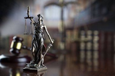 Hukuk teması. Heykel, yargıç tokmak ve hukuk fakültesi kütüphanesinde adalet terazisi..