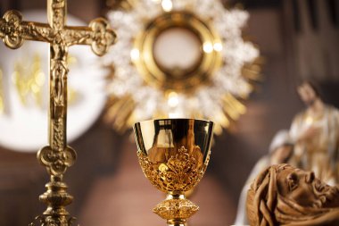Katolik dini kavramı. Katolik sembolleri kompozisyonu. Haç, Monstrance, Kutsal İncil ve ahşap sunakta altın kadeh.. 