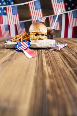 4 Temmuz kutlamaları. Amerikan bayrağı ve madalyaları. Köy ahşap masada hamburgerler.