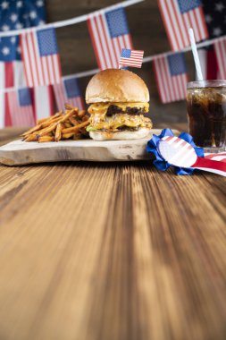 4 Temmuz kutlamaları. Amerikan bayrağı ve madalyaları. Köy ahşap masada hamburgerler.