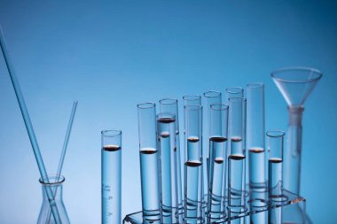 Coronavirus salgını teması. Hızlı covid testleri ve anti-covid aşısıyla ilgili bilimsel araştırma. Mavi arka planda deney tüpleri ve deney tüpleri.