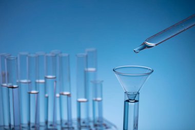 Coronavirus salgını teması. Hızlı covid testleri ve anti-covid aşısıyla ilgili bilimsel araştırma. Mavi arka planda deney tüpleri ve deney tüpleri.