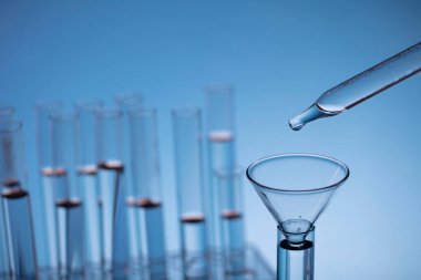 Coronavirus salgını teması. Hızlı covid testleri ve anti-covid aşısıyla ilgili bilimsel araştırma. Mavi arka planda deney tüpleri ve deney tüpleri.