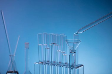 Coronavirus salgını teması. Hızlı covid testleri ve anti-covid aşısıyla ilgili bilimsel araştırma. Mavi arka planda deney tüpleri ve deney tüpleri.