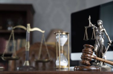 Yargıç odası. Gavel ve Themis heykeli kahverengi masanın üzerinde. Kitaplıkta yasal kitap koleksiyonu.