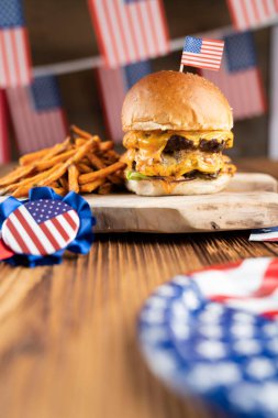 4 Temmuz kutlamaları. Amerikan bayrağı ve madalyaları. Köy ahşap masada hamburgerler.