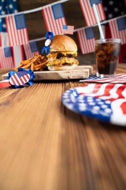 4 Temmuz kutlamaları. Amerikan bayrağı ve madalyaları. Köy ahşap masada hamburgerler.