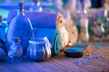 Spa ve sağlık konsepti. Kozmetik ürünü şişeler, havlular, banyo tuzu ve ahşap panellerde bakım ürünleri..