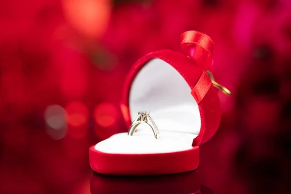 Романтическая Концепция Дня Свадебные Кольца Лежат Сияющем Столе Фоне Красных — стоковое фото