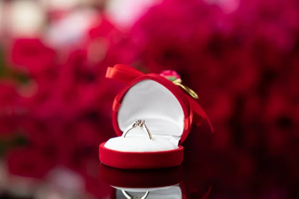 Romantikus Nap Koncepció Jegygyűrűk Fekvő Fényes Asztalon Vörös Rózsa Háttér — Stock Fotó