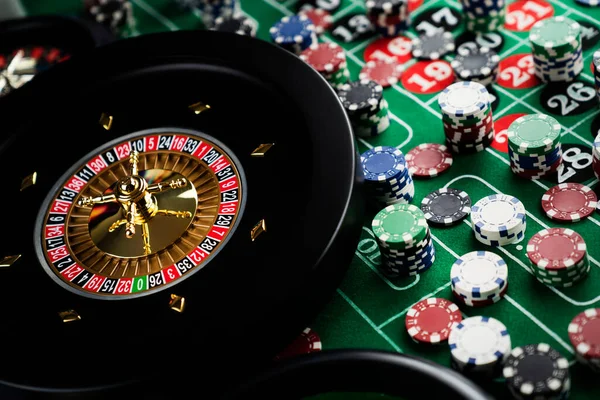 Roulette table in casino. Casino felt green table with red and black numbers. Stack of poker chips.